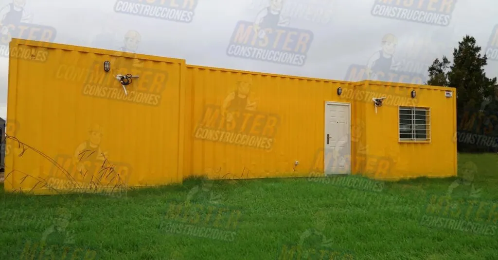 Casa contenedor amarilla con puerta blanca, ventana con rejas y paredes de contenedor visibles