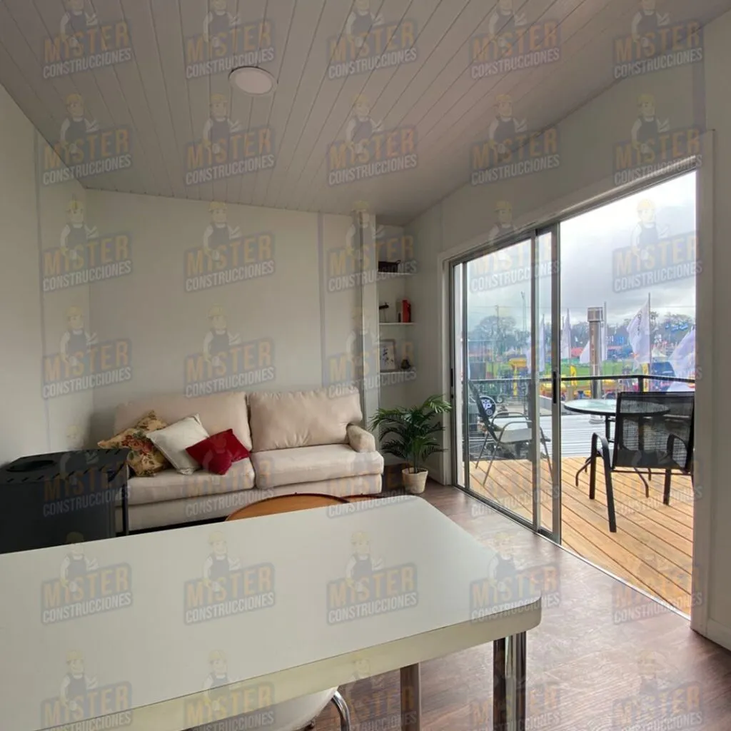 Interior de sala con sofá, mesa y acceso a terraza mediante puerta corrediza