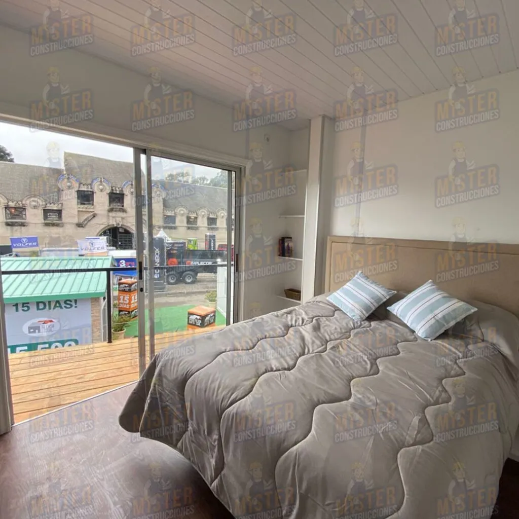 Interior de habitación con cama matrimonial, vista a la terraza y puerta corrediza