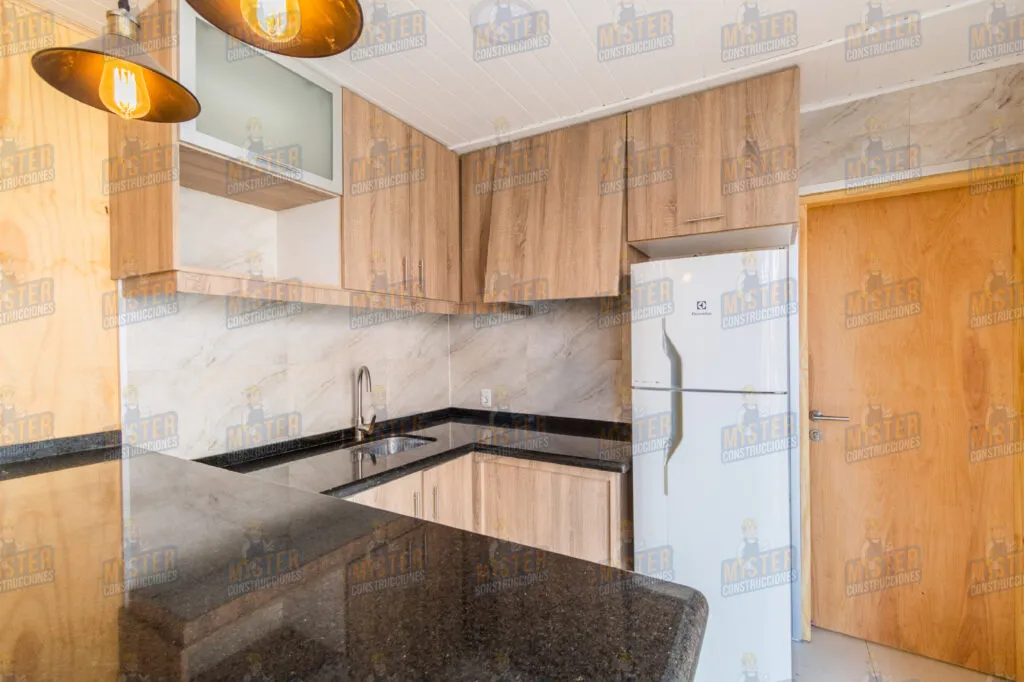 Cocina moderna con muebles de madera, encimera de granito y electrodomésticos blancos