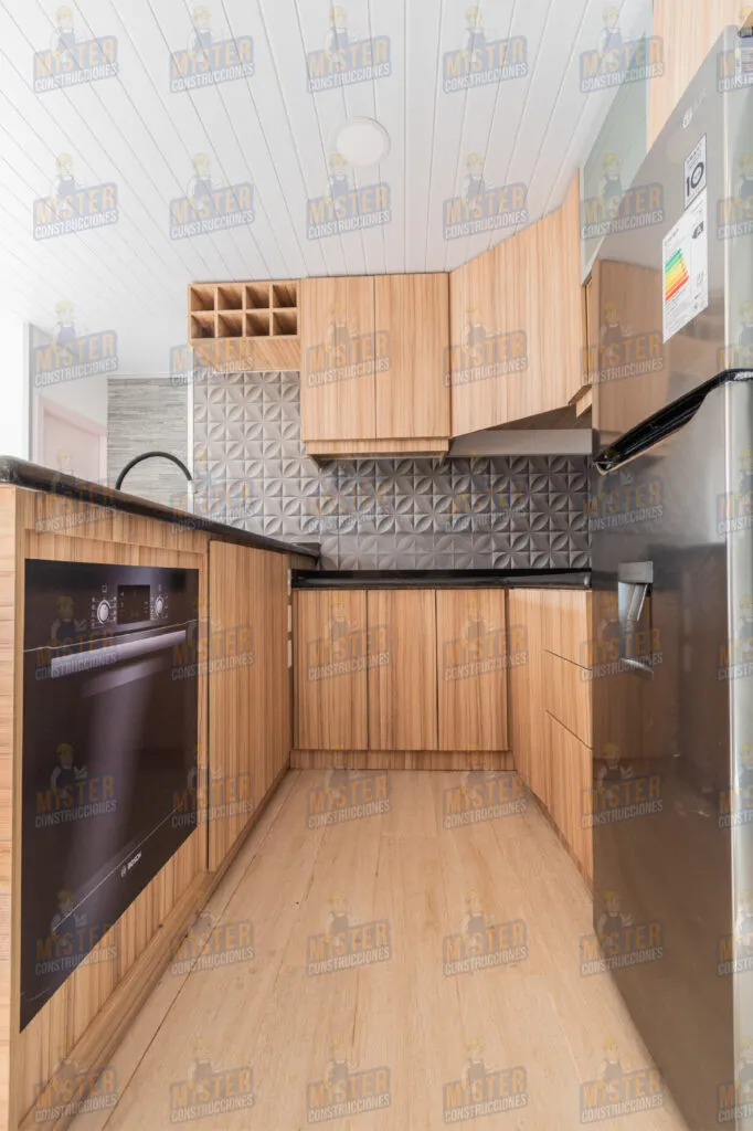 Cocina moderna con muebles de madera, encimera negra y electrodomésticos de acero inoxidable