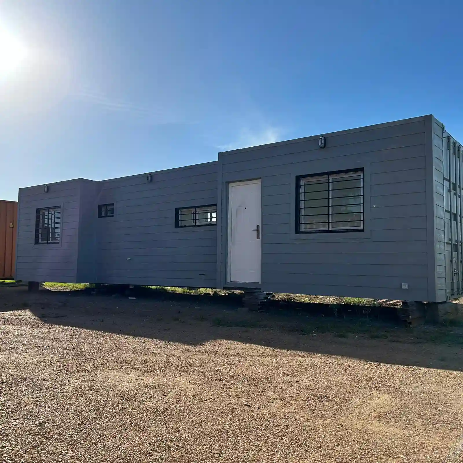 Casa contenedor 30 m² — siding gris, interiores luminosos